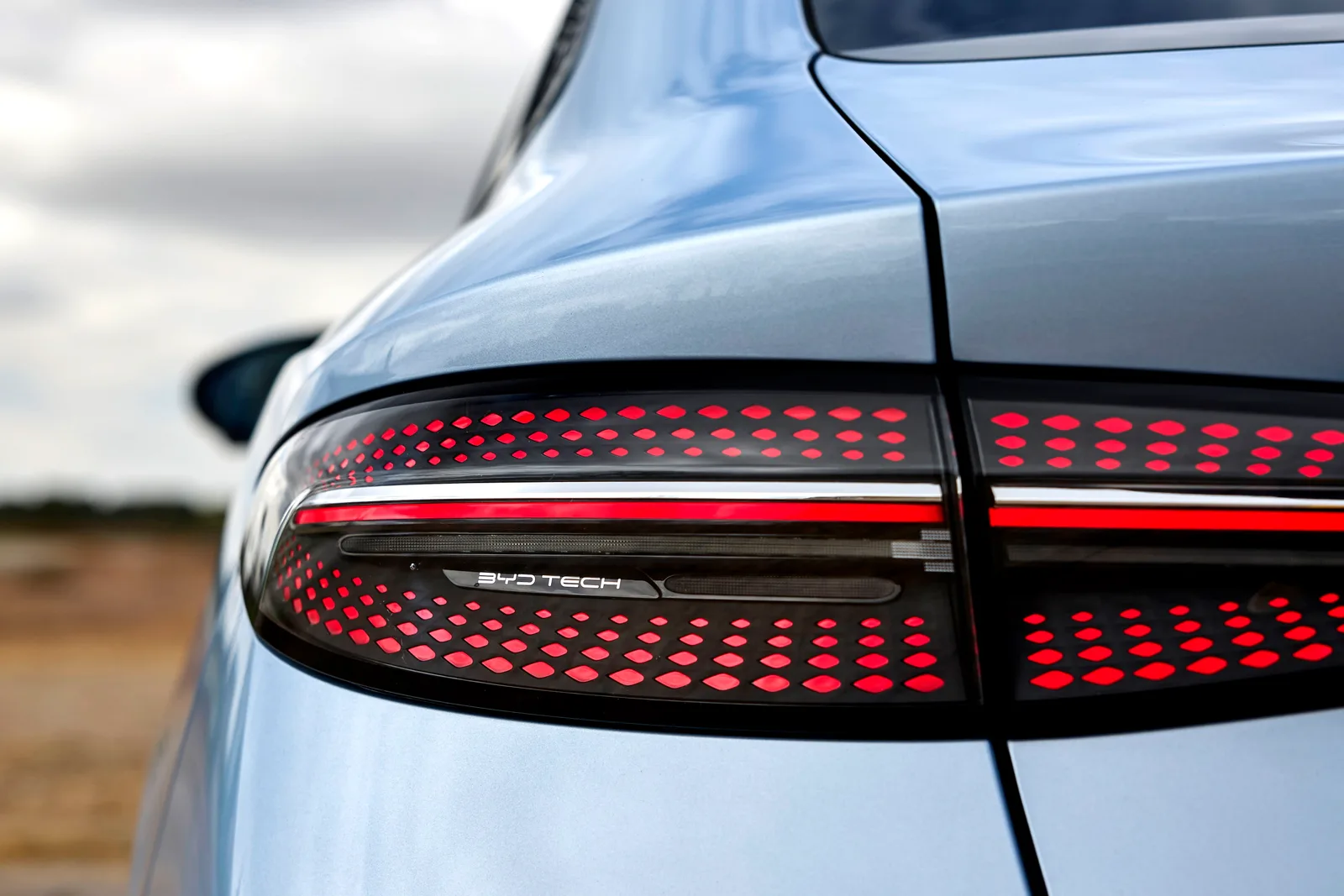 Zbliżenie na tylną lampę BYD Seal z charakterystycznym wzorem LED i napisem BYD Tech