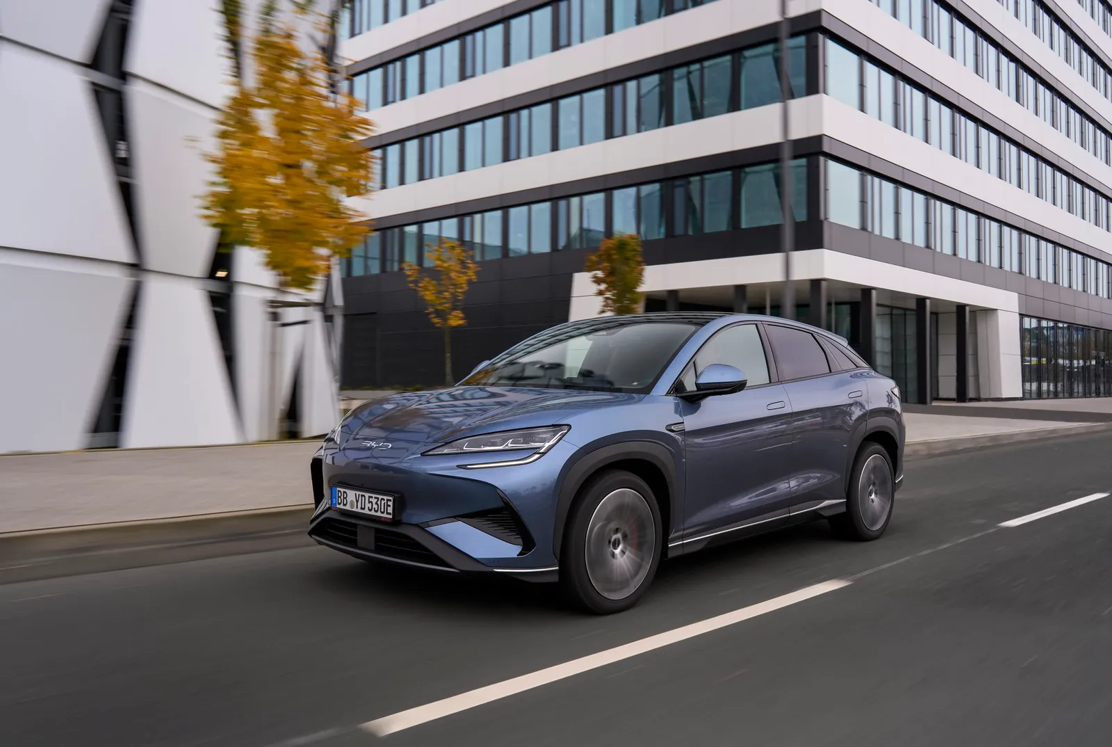 BYD Sealion 7 od przodu pod innym kątem, w tle nowoczesny biurowiec ze szklaną fasadą