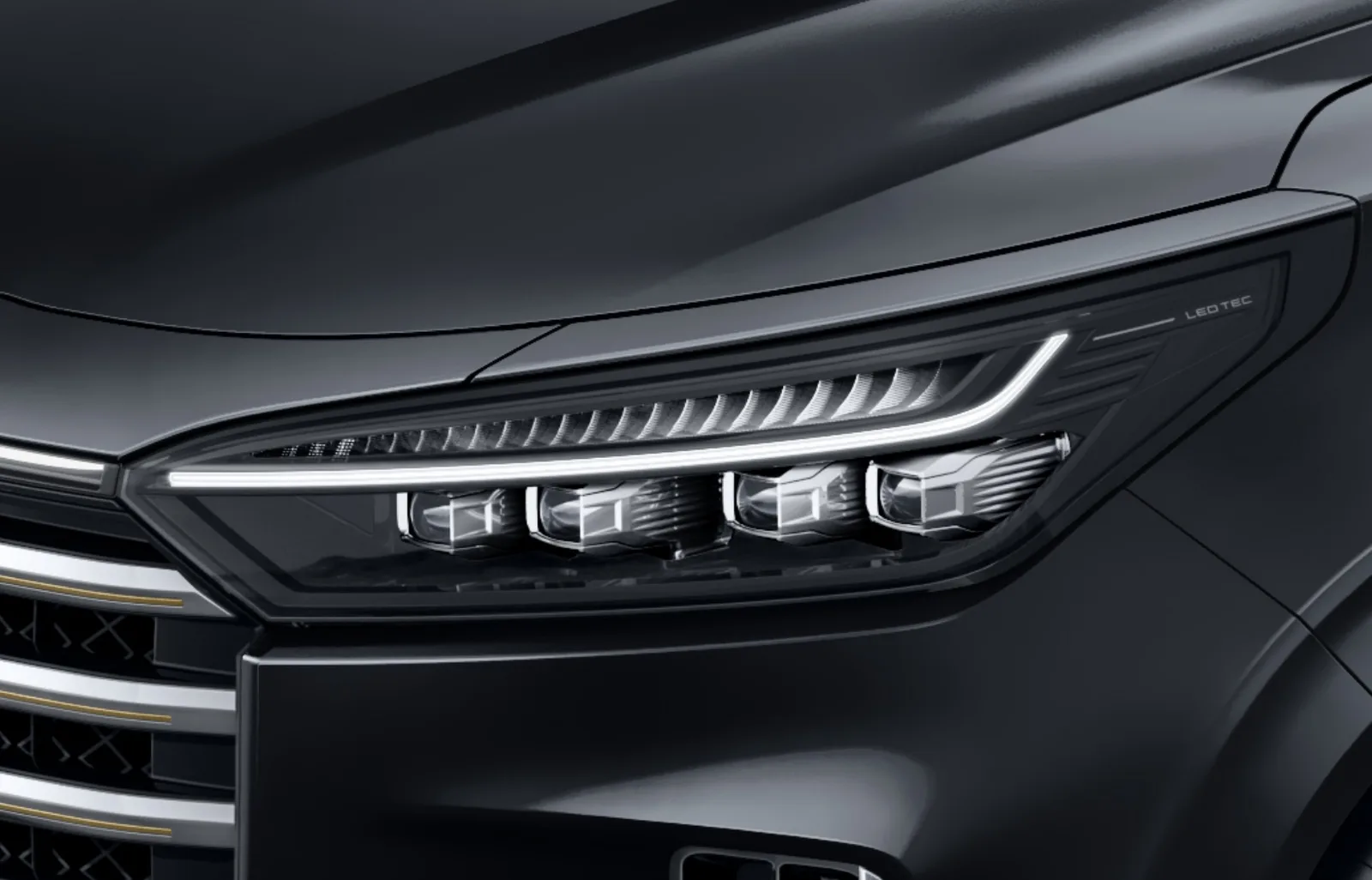 Exeed VX - zbliżenie na reflektor LED i grill przedni w czerni