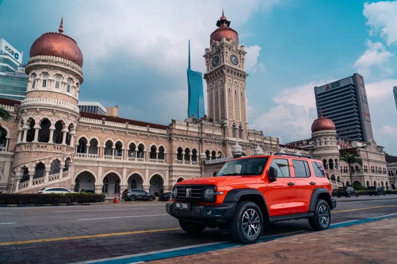 GWM Tank 300 w kolorze pomarańczowym na tle Sultan Abdul Samad Building w Kuala Lumpur
