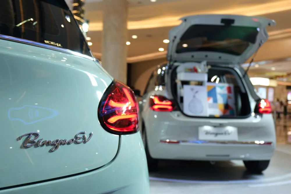 Wuling Bingo, tyl nadwozia w kolorze mietowym z widocznym logo BinguoEV i otwarta klapa bagaznika w tle