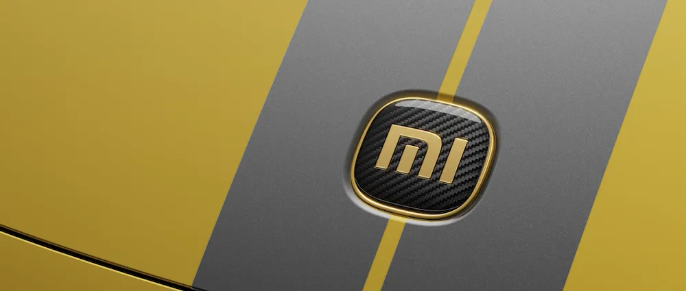 Zbliżenie na emblemat Xiaomi z 24-karatowego złota i włókna węglowego na masce SU7 Ultra