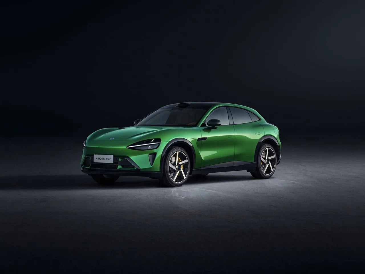 Zielone Xiaomi YU7 zaparkowane na tle ciemnego tła, widoczna sylwetka SUV-a
